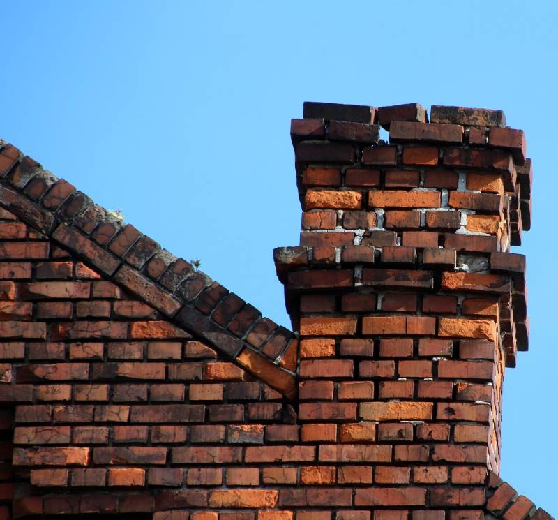 Damaged chimney on an Burleson home showing cracks and missing mortar